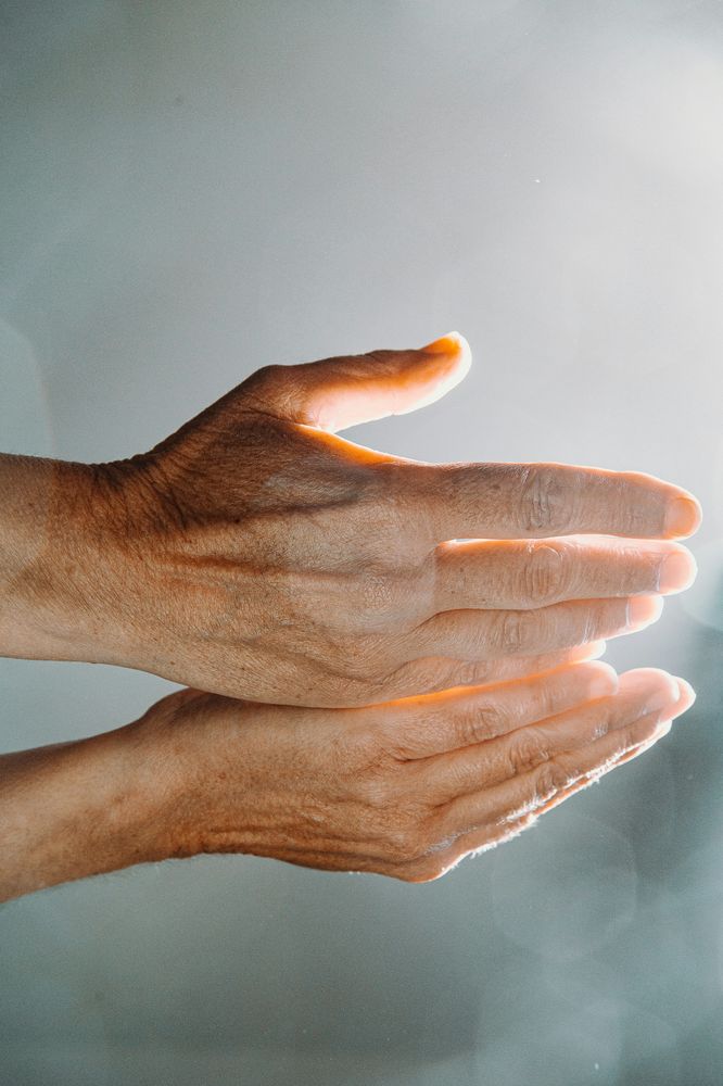 An experienced hand gently supporting another